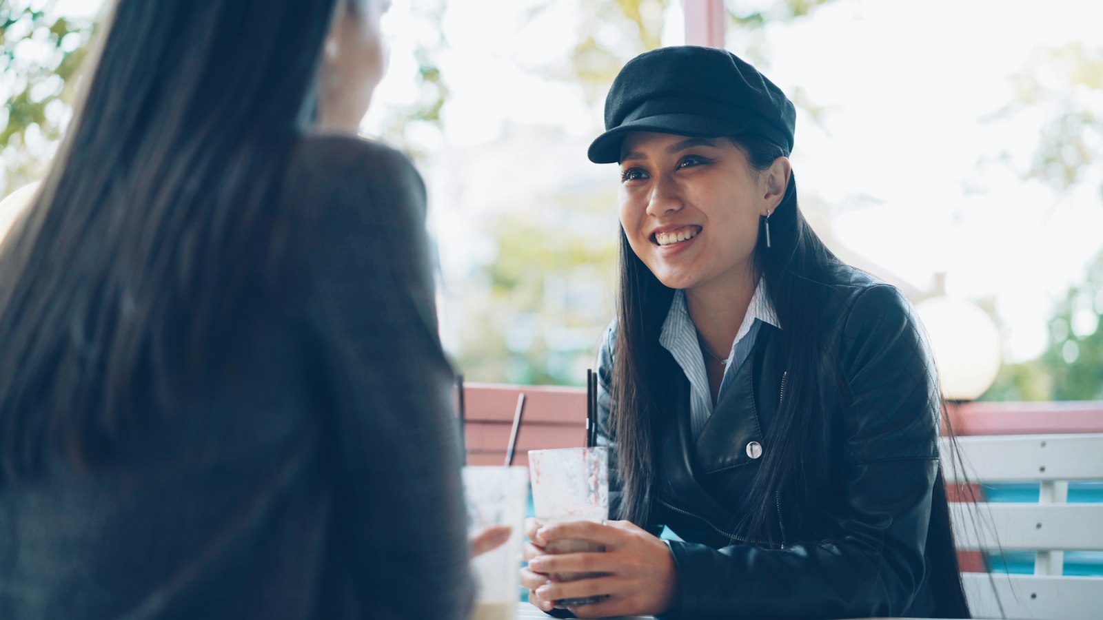 Two friends laughing and talking at a street café